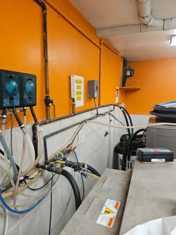 Hot and cold supply piping, valves and hoses feeding commercial laundry machines