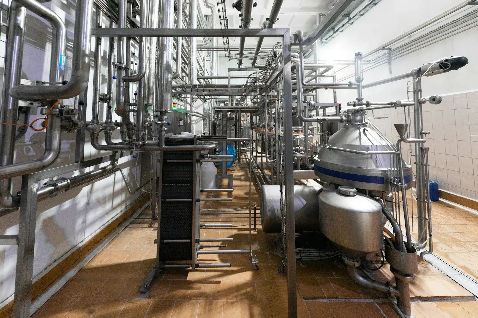 Stainless steel industrial piping, tanks and a heat exchanger in a processing facility