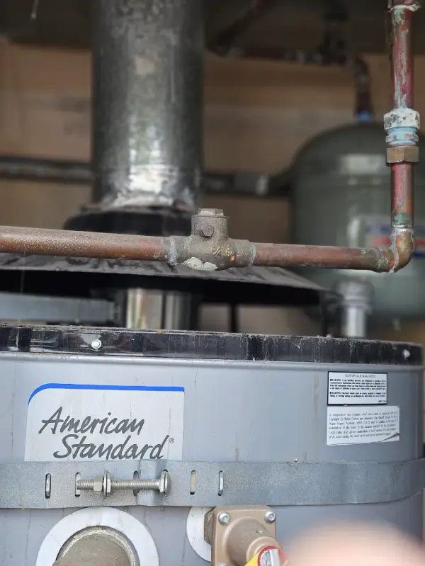 Gas connection and copper water line on top of an American Standard commercial water heater