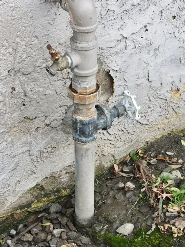 Galvanized riser with a hose bibb and gate valve at the exterior wall of a building