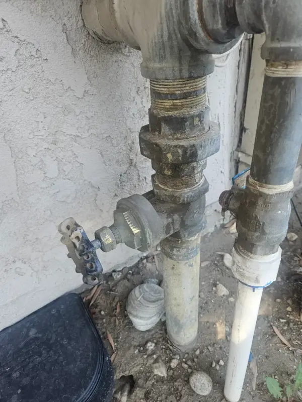 Galvanized water service riser with a gate valve and hose bibb at the outside wall of a house