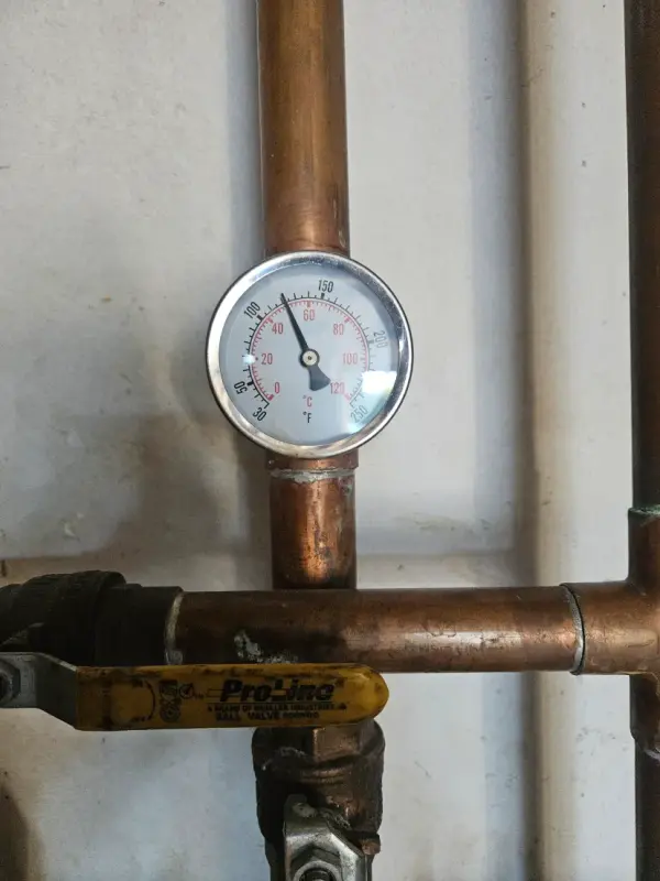 Temperature gauge on a copper hot water line above a Pro-Line ball valve