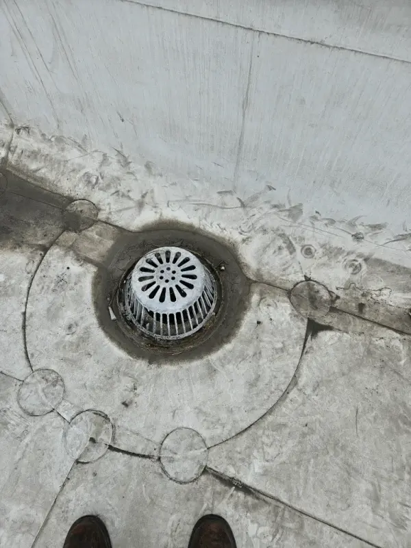 New strainer dome set into a flat roof drain and sealed into the roofing membrane