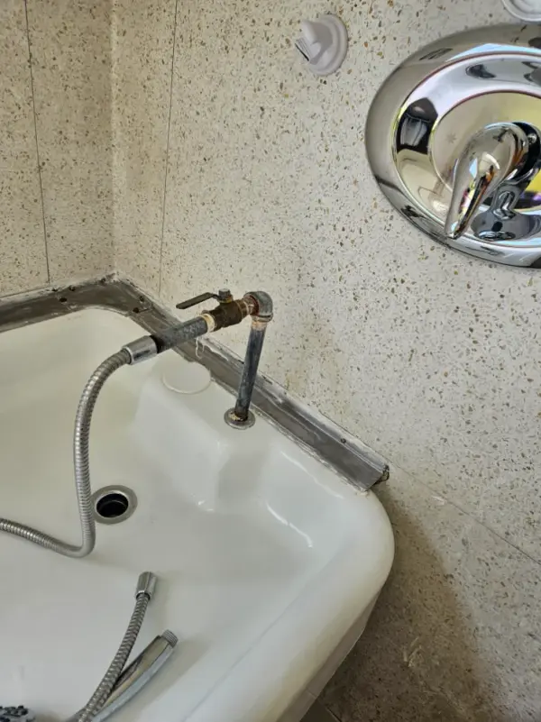 Service sink fitted with a hose connection and shutoff valve in a commercial restroom