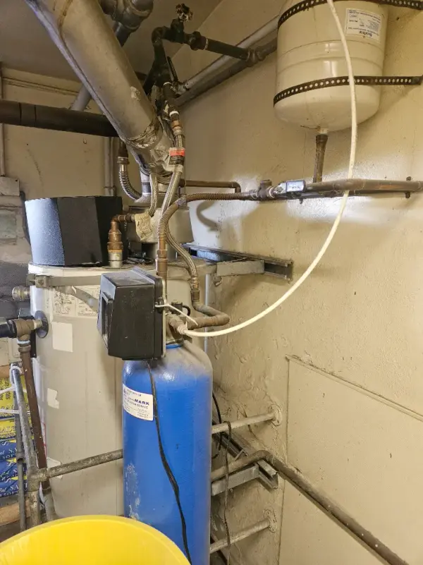 Water heater with a blue water softener, wall-mounted expansion tank and copper supply lines