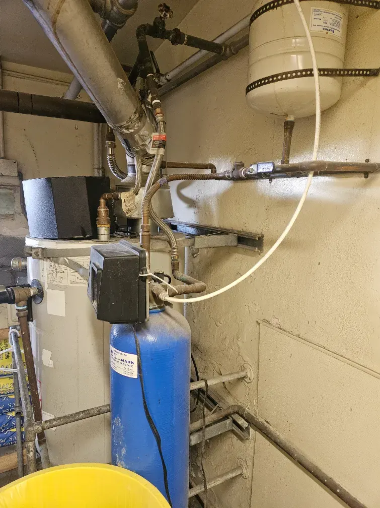 Water heater with a blue water softener, wall-mounted expansion tank and copper supply lines